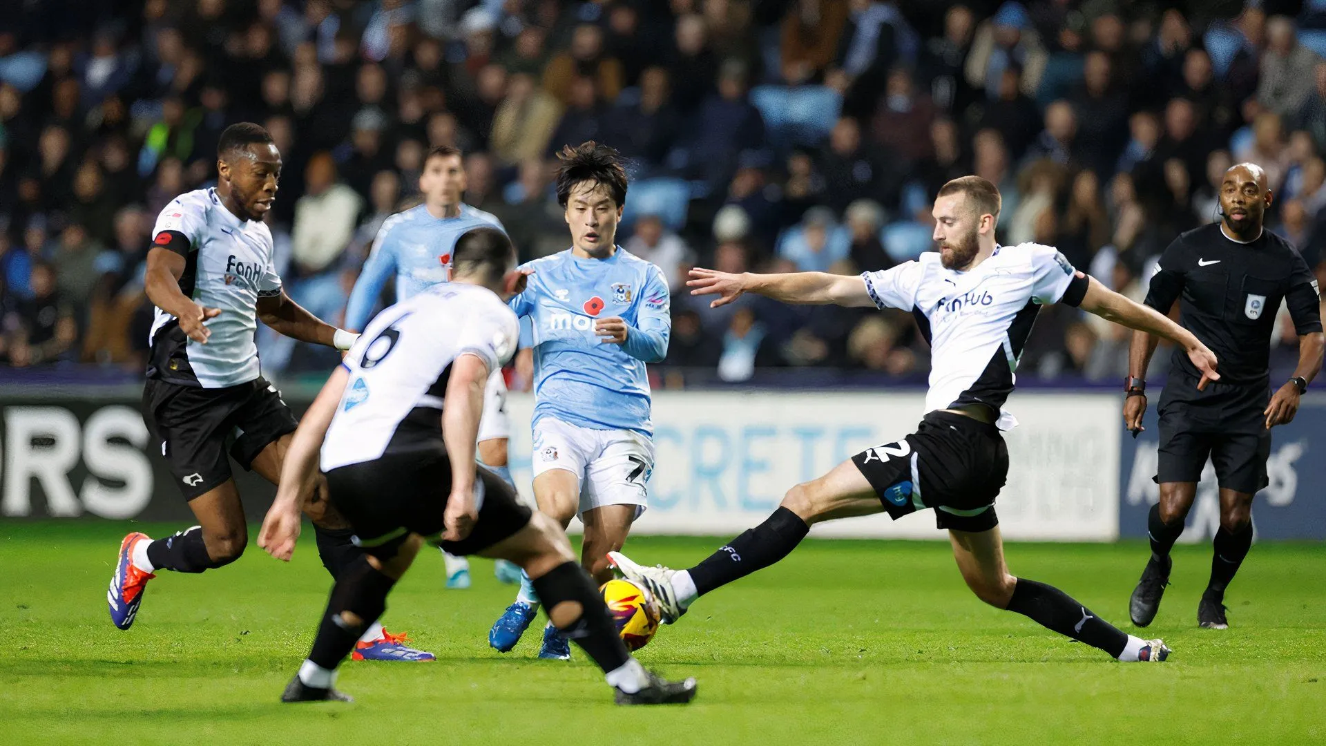 Ebou Adams (trái) của Derby County trong một pha tranh chấp bóng quyết liệt với Tatsuhiro Sakamoto, phía sau là Nathaniel Phillips.